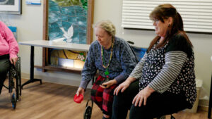 A woman playing a game with a nurse at a skilled nursing facility