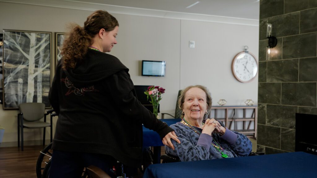 A nurse smiles at a woman at a respite care facility