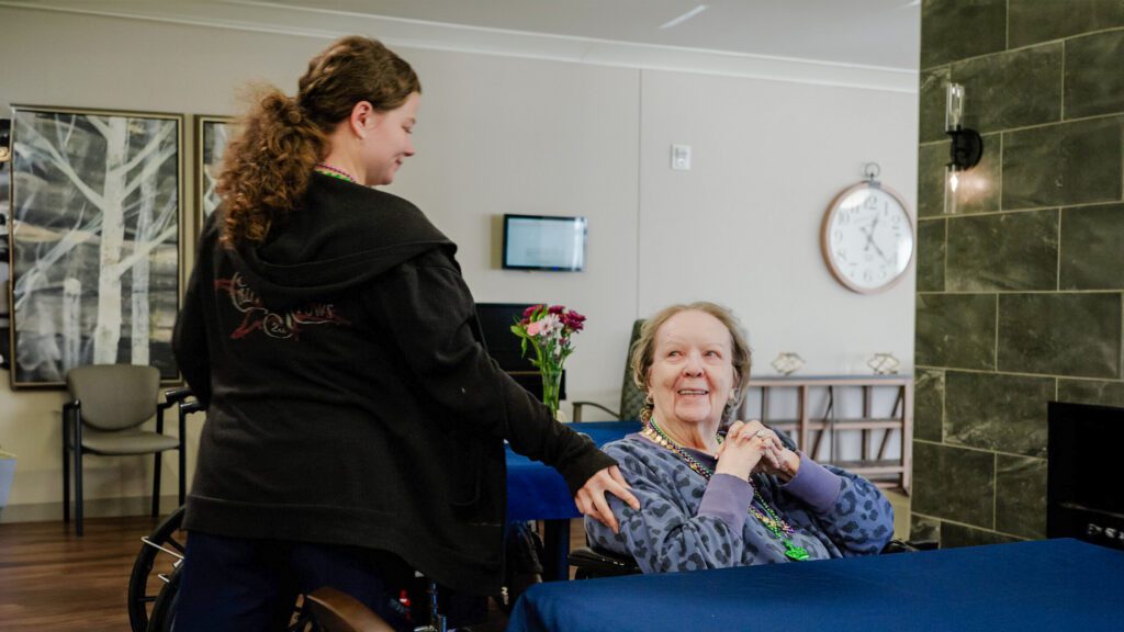 a nurse smiling at a smiling resident at a skilled nursing facility