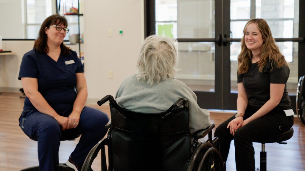 two nurses smiling and talking to a respite care resident